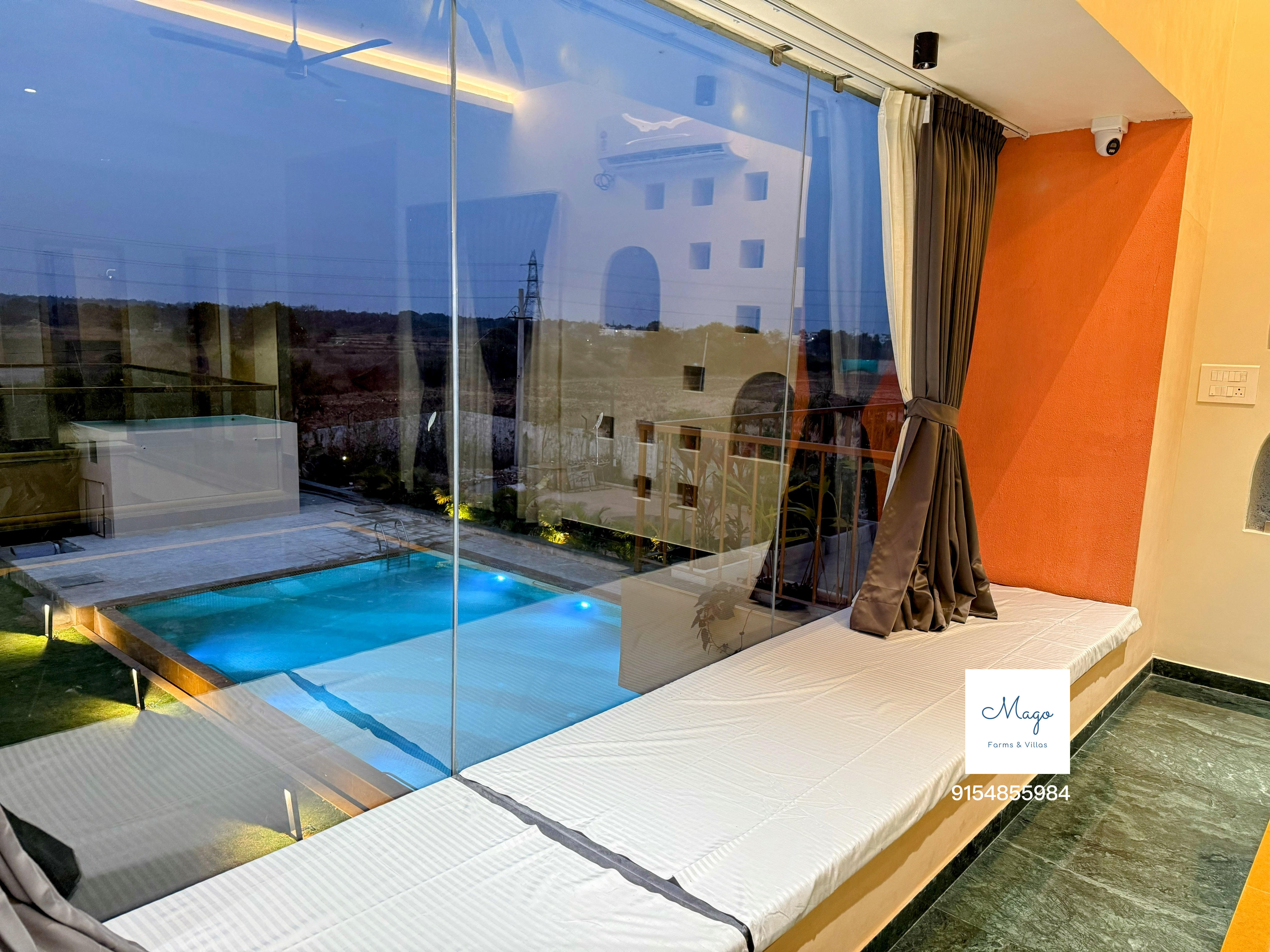 Daybed overlooking the pool through floor-to-ceiling glass