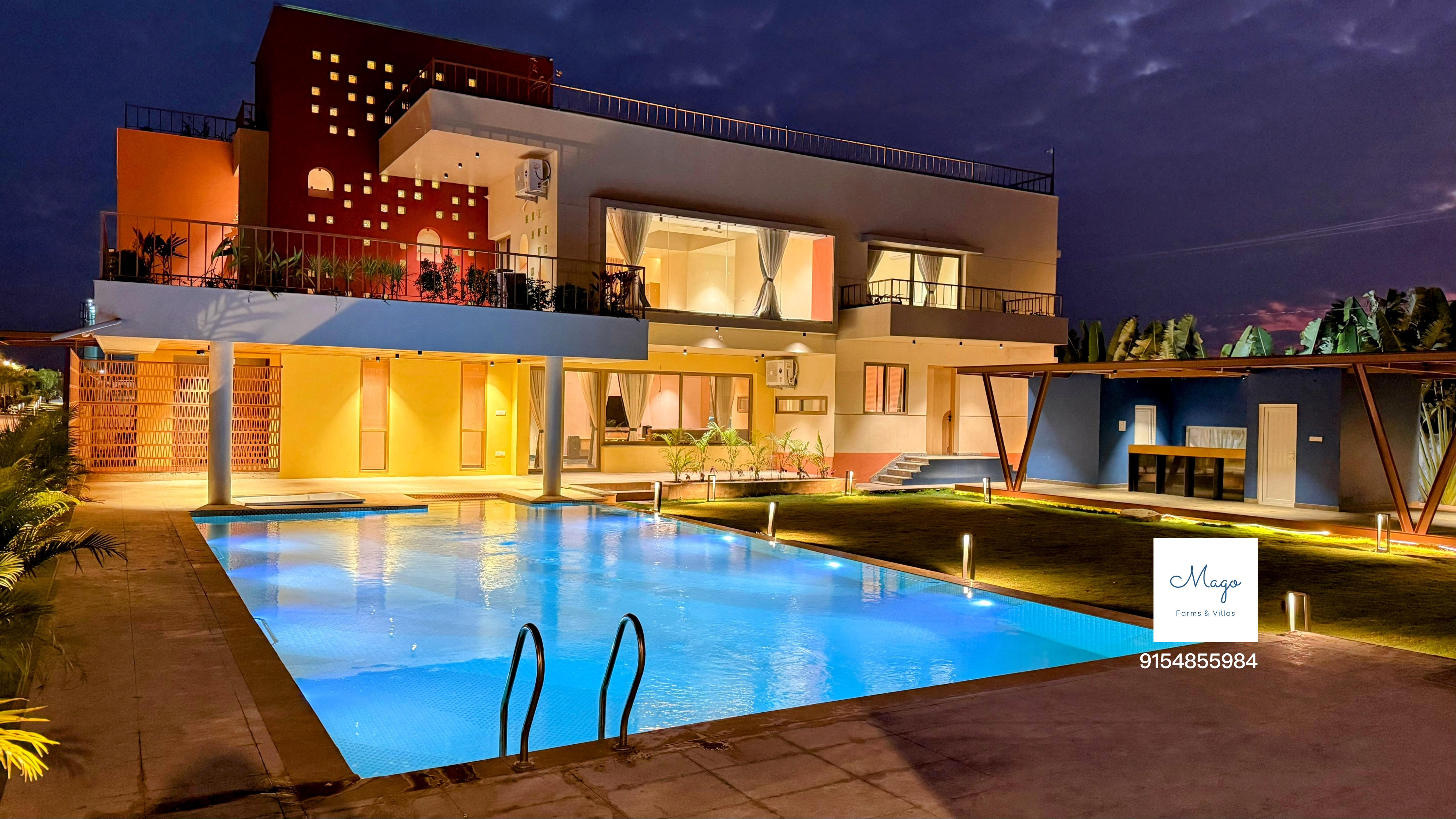 The Terraskye villa and swimming pool lit up at dusk